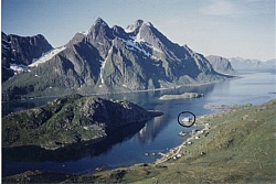 De høye Himmeltindene og Steinfjorden som deler seg i Tangstadpollen og Mærvollpollen (nærmest). Sjøhuset med rorbucamping er innsirklet.