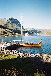 Vikingskipet Lofotr, Skarvhellodden. I bakgrunnen det store hvitmalte sjøhuset der Steinfjorden går over i Mærvollpollen. Ovenfor sjøhuset ses det hvite våningshuset med nummer 205 (resepsjon).